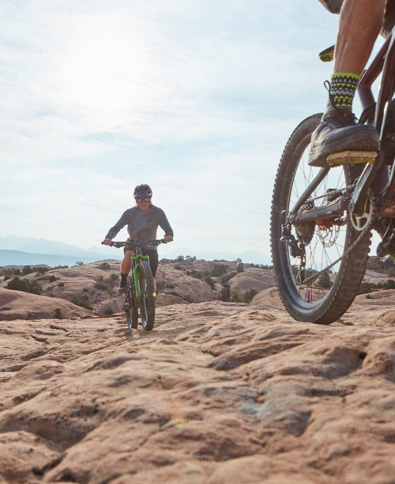 Buy stock photo Cropped shot of two athletic men mountain biking through the wilderness