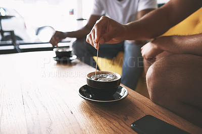 Buy stock photo Cropped shot of two men having coffee while sitting together in a cafe