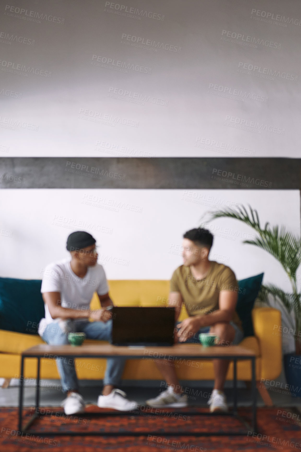 Buy stock photo Shot of two young men sitting together in a coffee shop