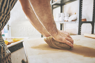 Buy stock photo Shot of an unrecognisable man kneading clay in a pottery studio