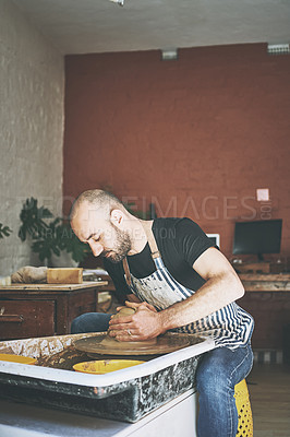 Buy stock photo Shot of a young man working with clay in a pottery studio