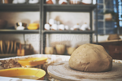 Buy stock photo Shot of a lump of clay on a pottery wheel in a ceramic studio