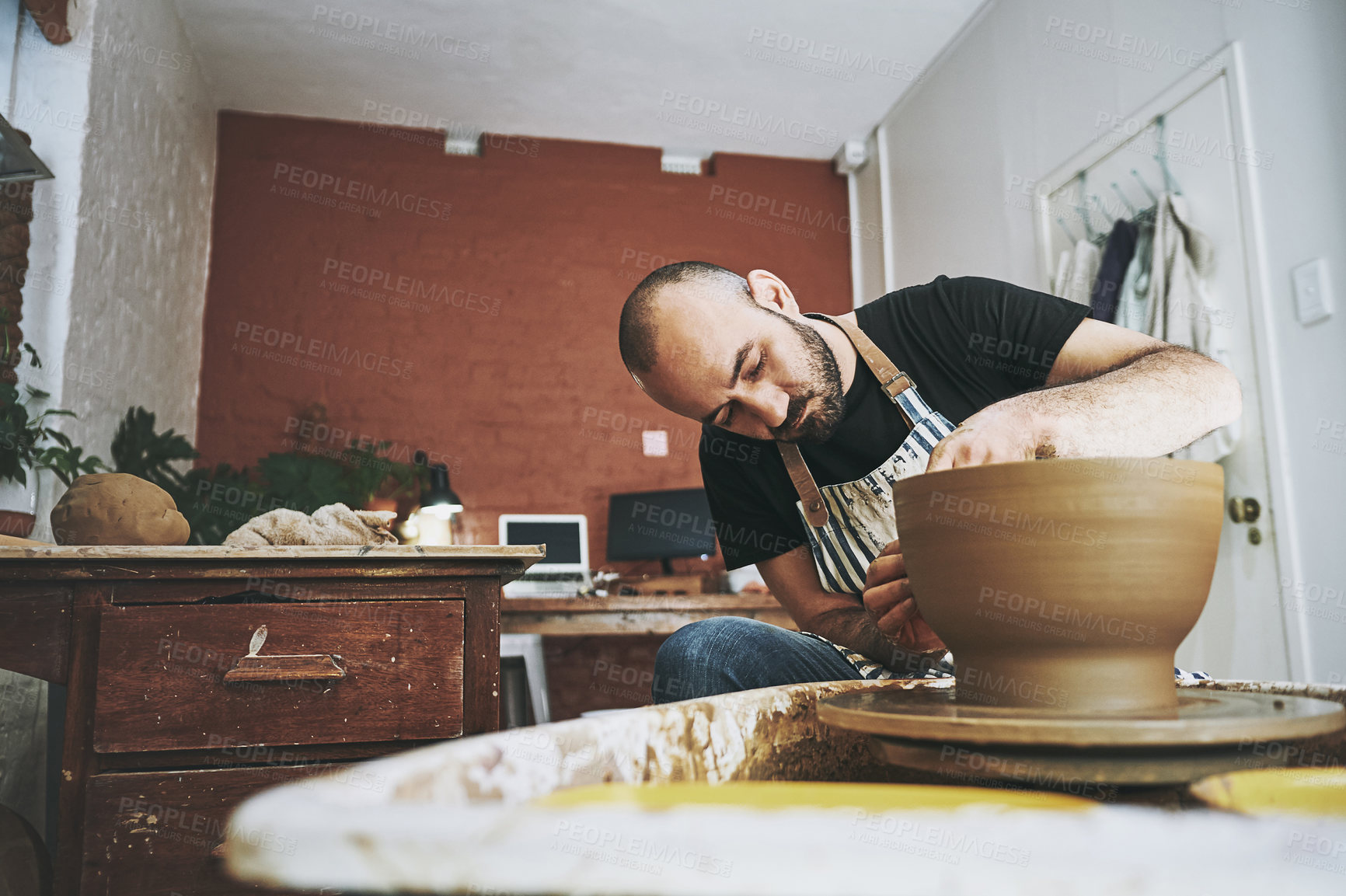 Buy stock photo Shot of a young man working with clay in a pottery studio