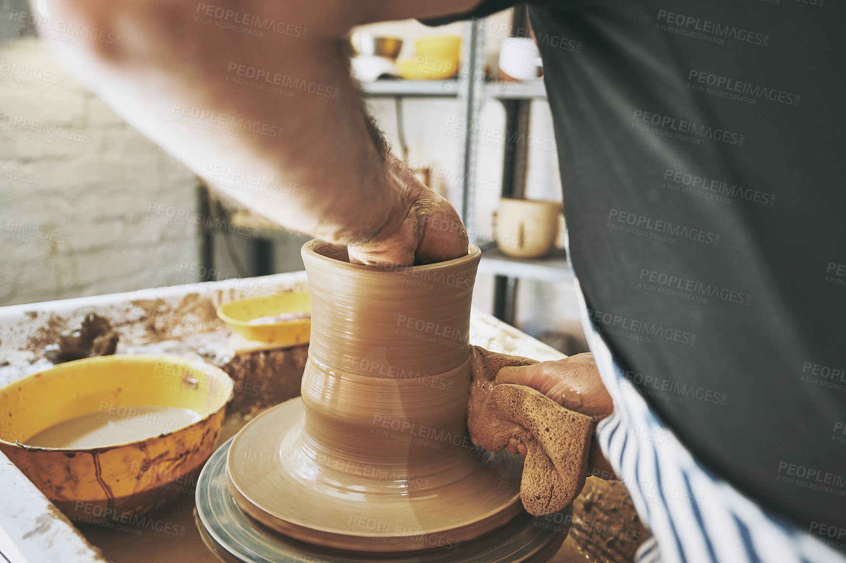 Buy stock photo Shot of an unrecognisable man working with clay in a pottery studio