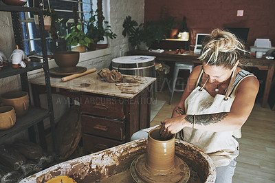 Buy stock photo Shot of a young woman working with clay in a pottery studio