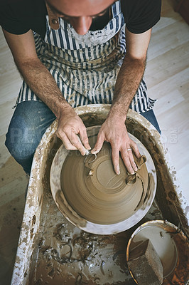 Buy stock photo Shot of a man working with clay in a pottery studio