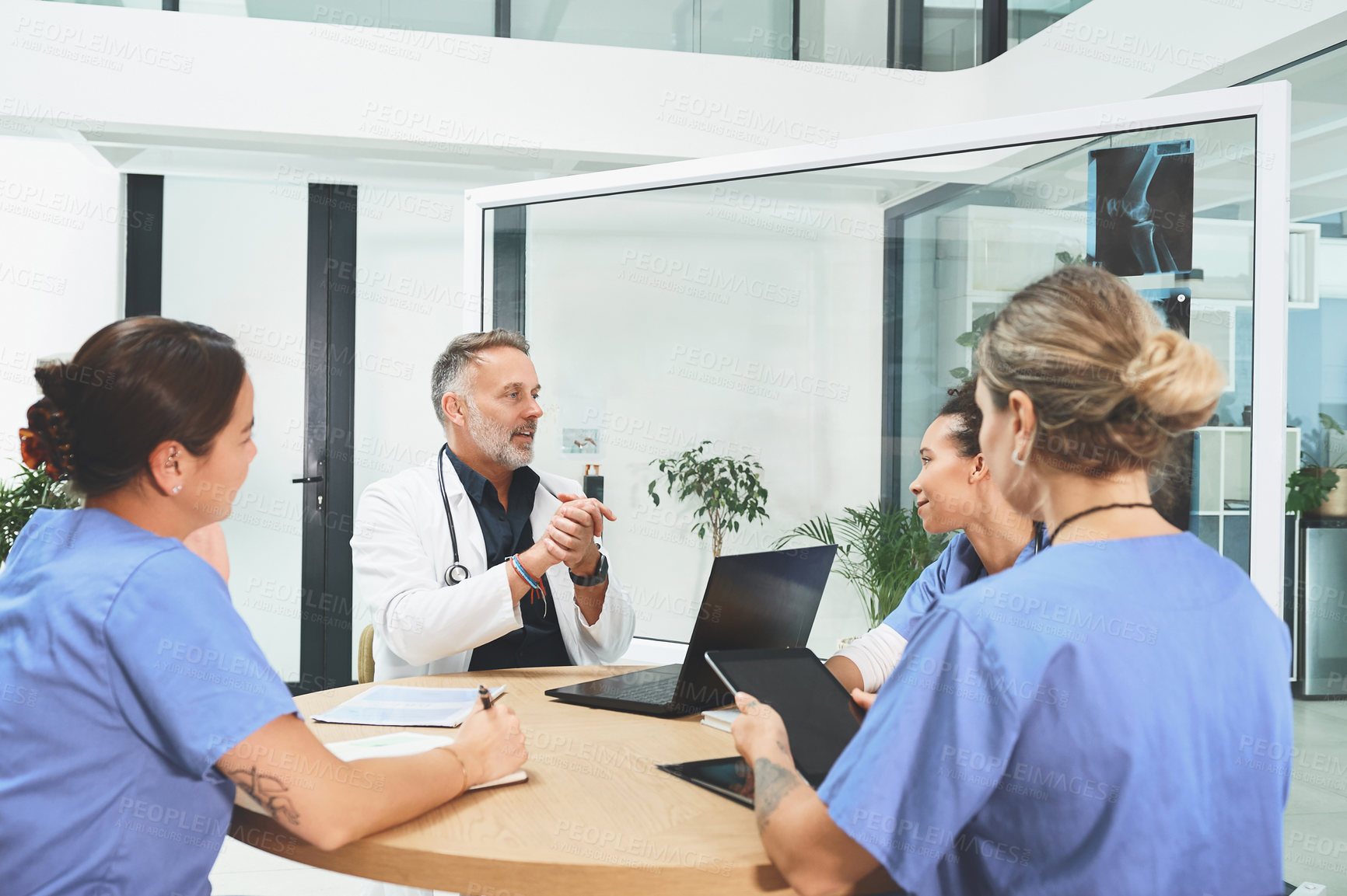 Buy stock photo Shot of a team of doctors having a meeting in a hospital