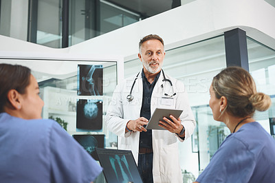 Buy stock photo Shot of a mature doctor leading a discussion with his colleagues in a hospital