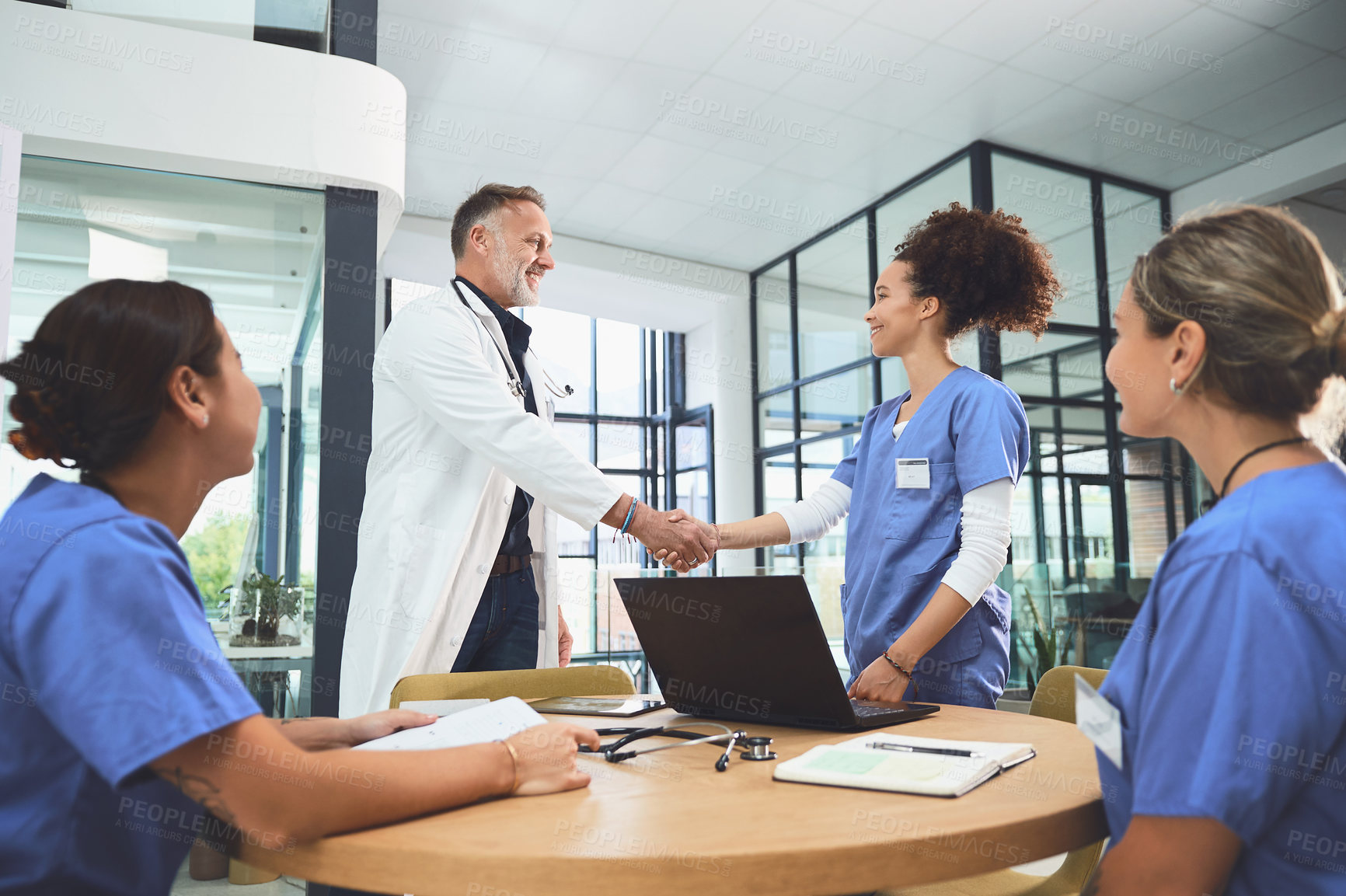 Buy stock photo Shot of doctors shaking hands during a meeting in a hospital