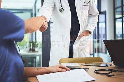 Buy stock photo Closeup shot of doctors shaking hands during a meeting in a hospital