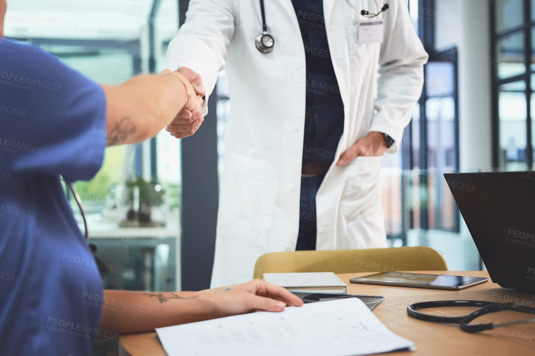 Buy stock photo Closeup shot of doctors shaking hands during a meeting in a hospital