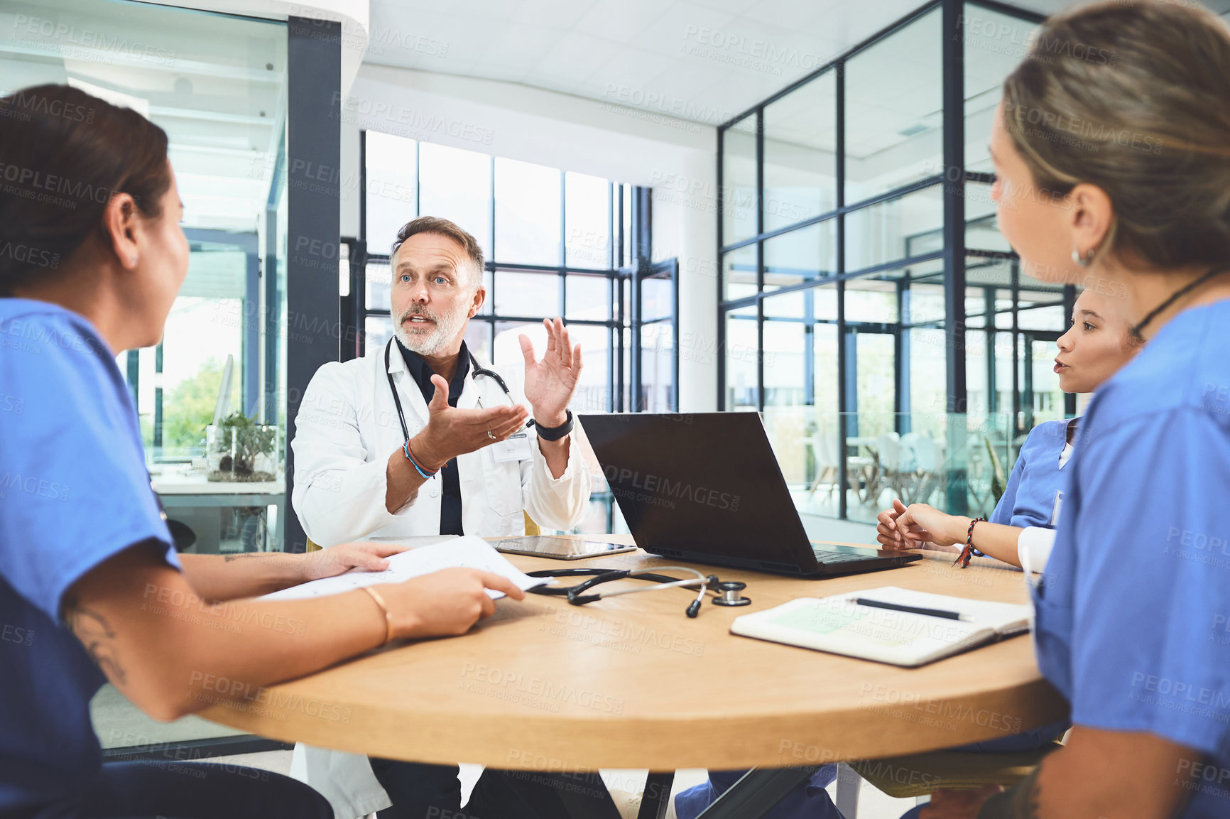 Buy stock photo Shot of a team of doctors having a meeting in a hospital