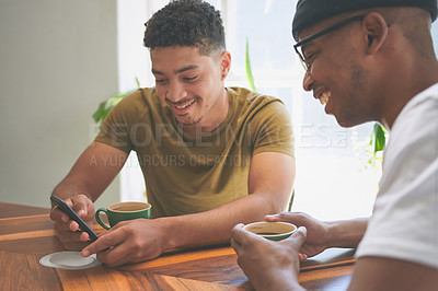 Buy stock photo Cropped shot of two handsome friends sitting together and using a cellphone during a discussion in a coffeeshop