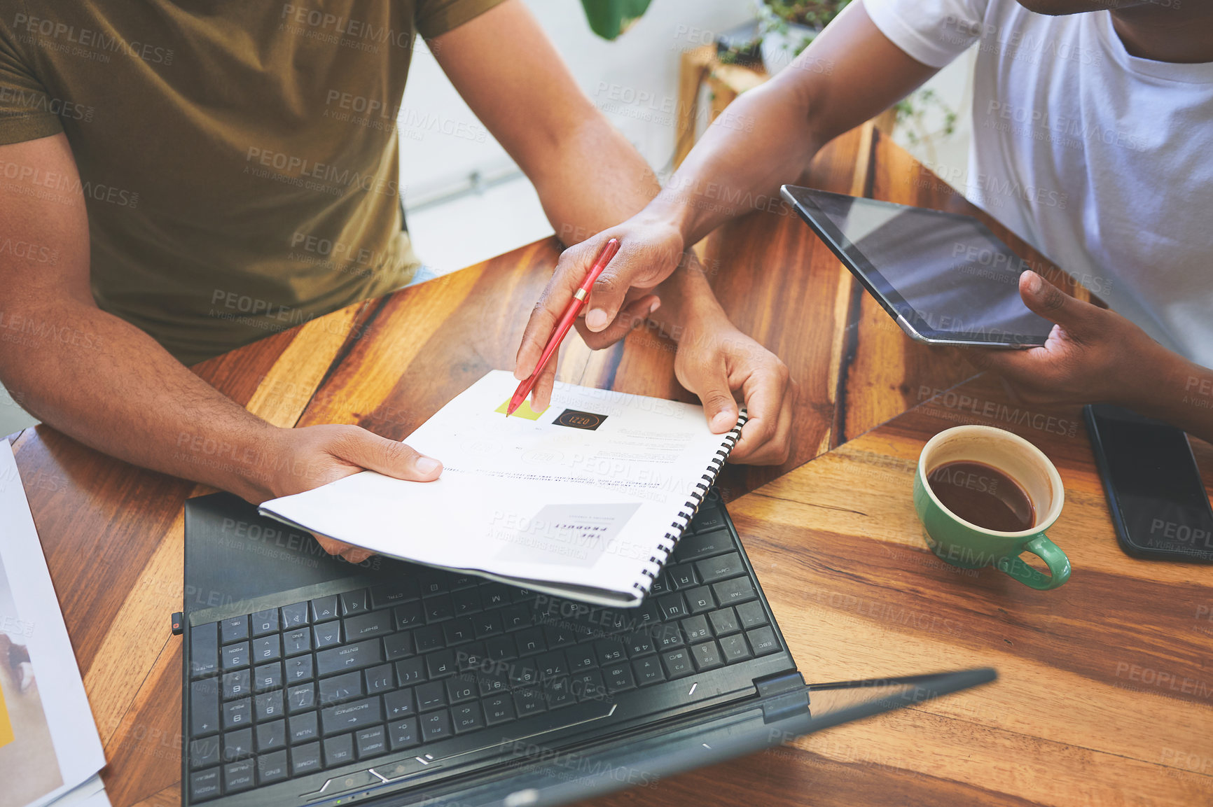 Buy stock photo Cropped shot of two unrecognizable friends sitting together and going through paperwork in a coffeeshop