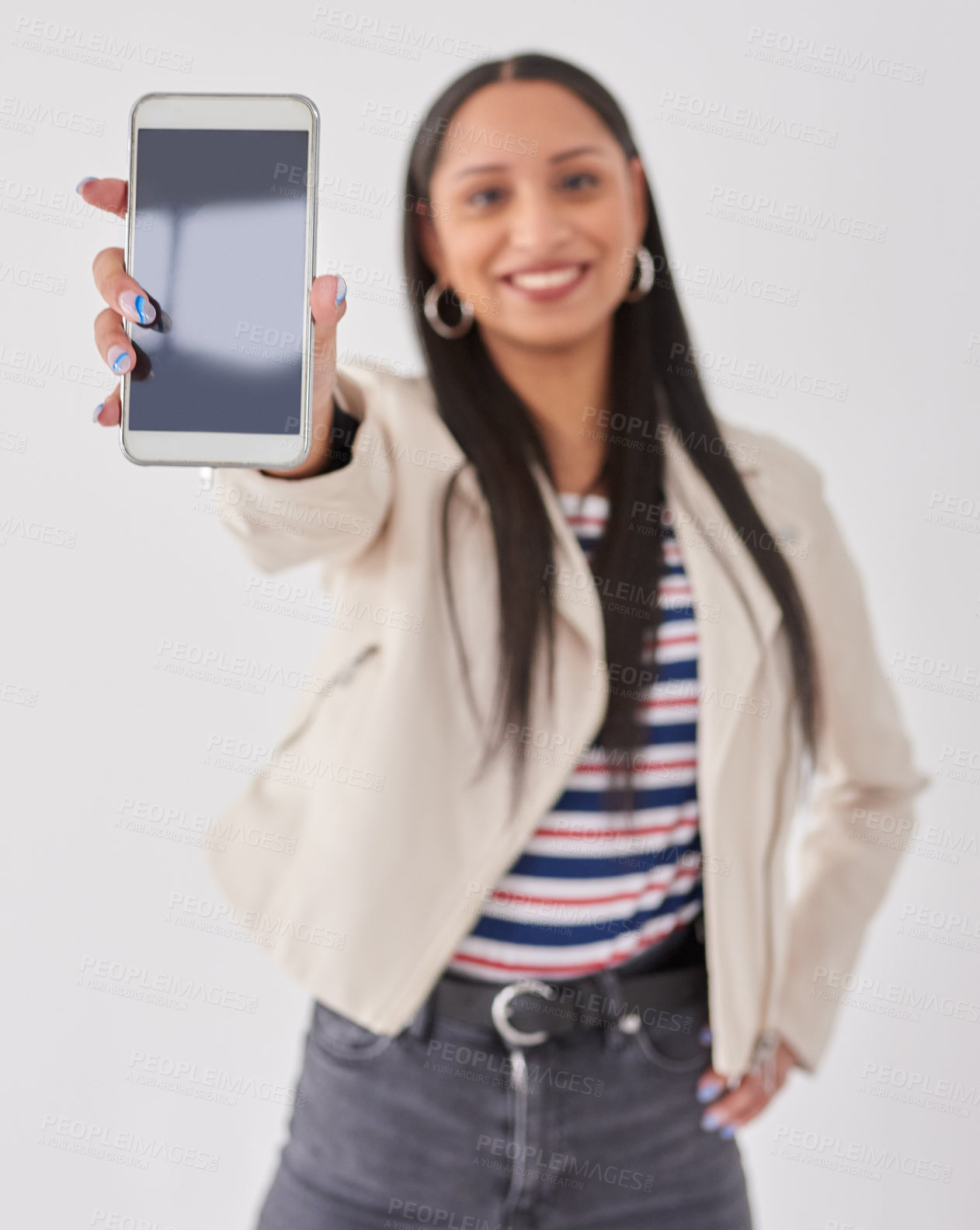 Buy stock photo Studio portrait of a young woman holding a cellphone with a blank screen against a white background