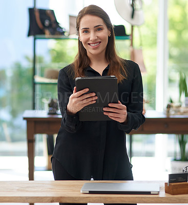 Buy stock photo Portrait of a young business owner using a digital tablet in her clothing store
