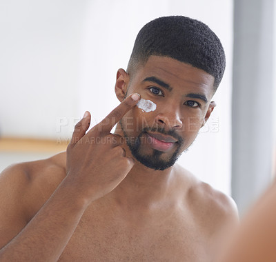 Buy stock photo Man, face and beauty with mirror and cream, skincare with hygiene and grooming during morning routine at home. Male person in bathroom, portrait with lotion and clean facial, wellness and moisturizer
