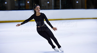 Buy stock photo Shot of a young woman figure skating at a sports arena