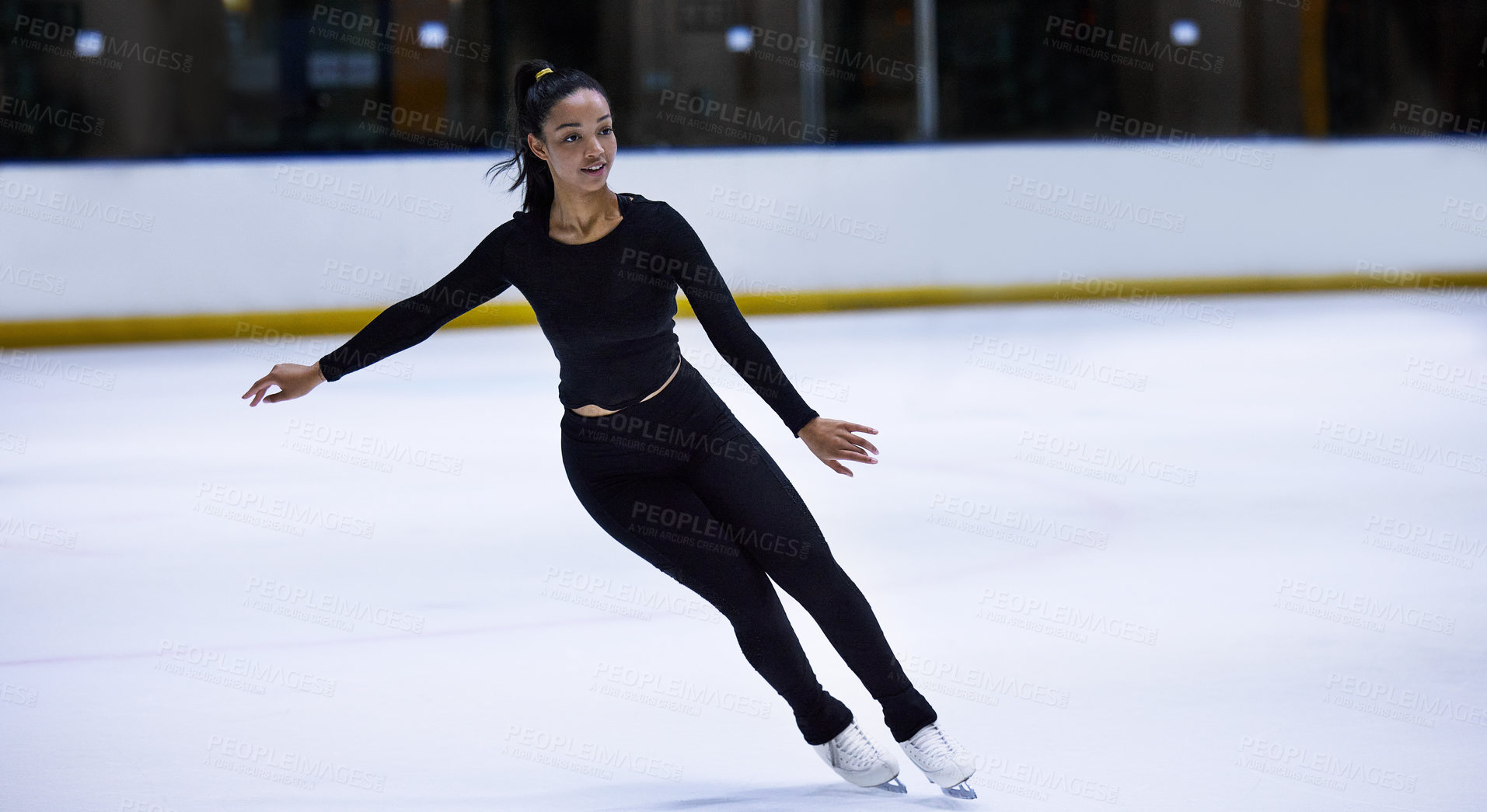 Buy stock photo Shot of a young woman figure skating at a sports arena