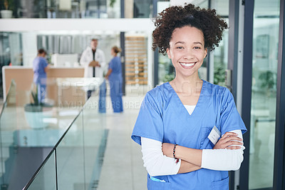 Buy stock photo Cropped portrait of an attractive young nurse standing with her arms folded in the clinic during the day