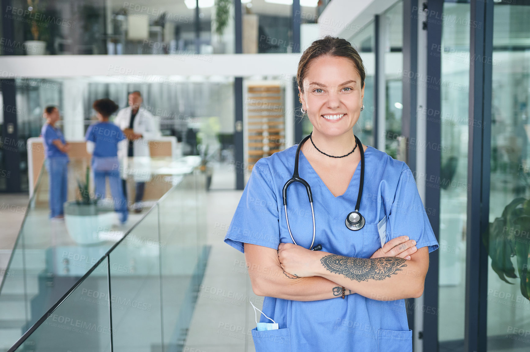Buy stock photo Cropped portrait of an attractive young nurse standing in the clinic during the day with her arms folded