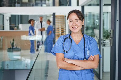 Buy stock photo Cropped portrait of an attractive young nurse standing in the clinic during the day with her arms folded