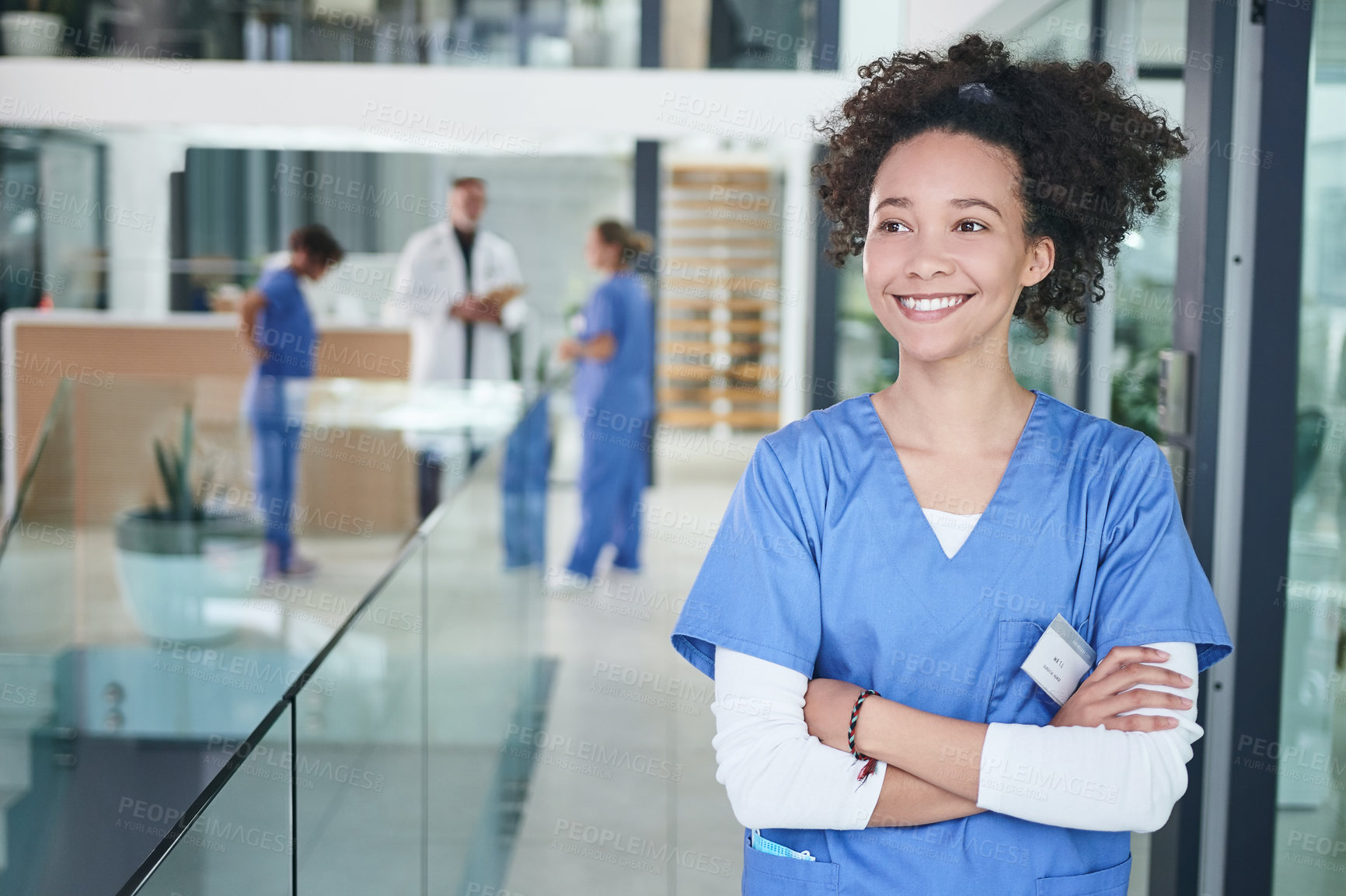 Buy stock photo Cropped shot of an attractive young nurse standing in the clinic during the day with her arms folded