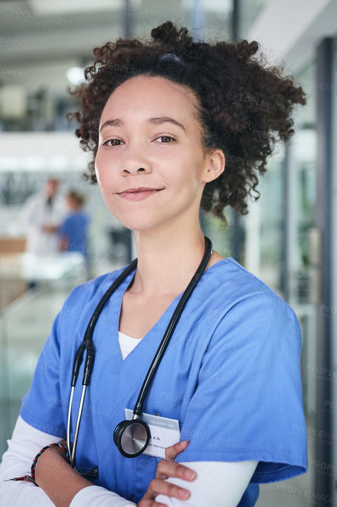 Buy stock photo Cropped portrait of an attractive young nurse standing in the clinic during the day with her arms folded