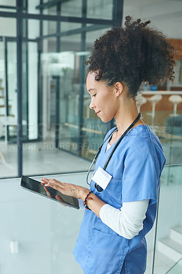 Buy stock photo Cropped shot of an attractive young nurse standing and using a digital tablet in the clinic