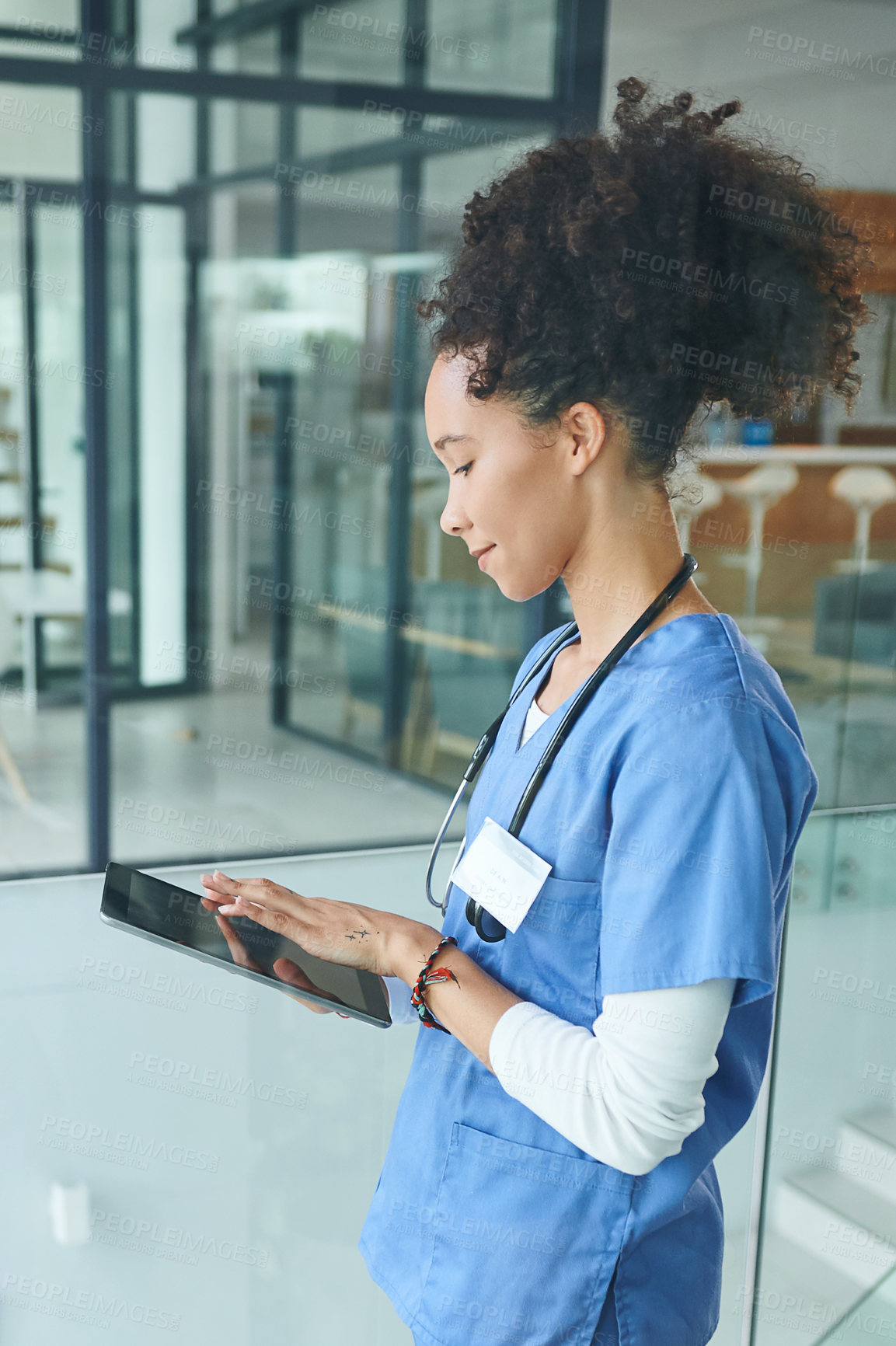 Buy stock photo Cropped shot of an attractive young nurse standing and using a digital tablet in the clinic