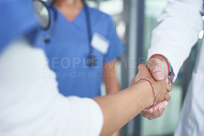 Buy stock photo Cropped shot of an unrecognizable nurse standing and shaking a doctor's hand in the clinic