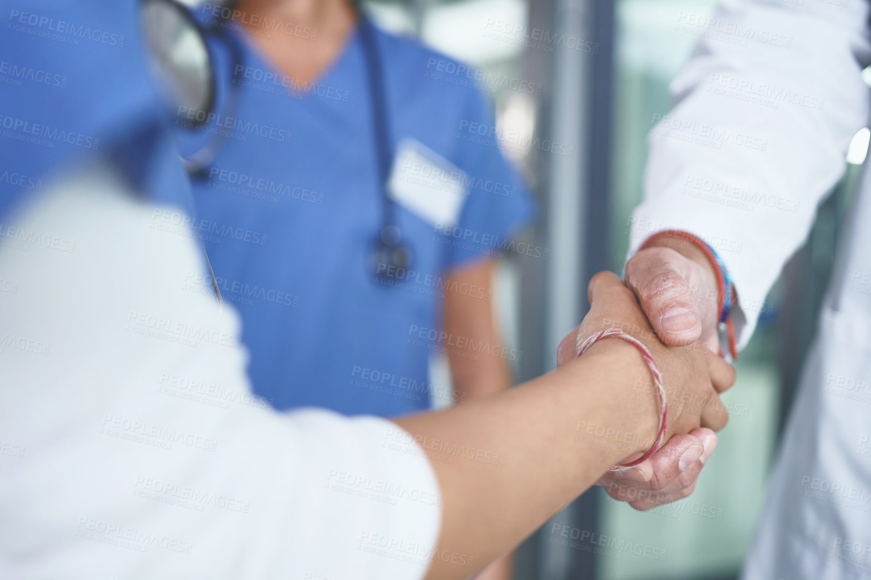 Buy stock photo Cropped shot of an unrecognizable nurse standing and shaking a doctor's hand in the clinic