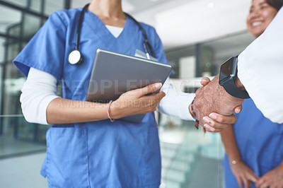 Buy stock photo Cropped shot of an unrecognizable doctor standing and shaking a nurse's hand in the clinic