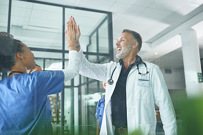 Buy stock photo Cropped shot of a handsome mature doctor standing and giving his nurse a high five in the clinic