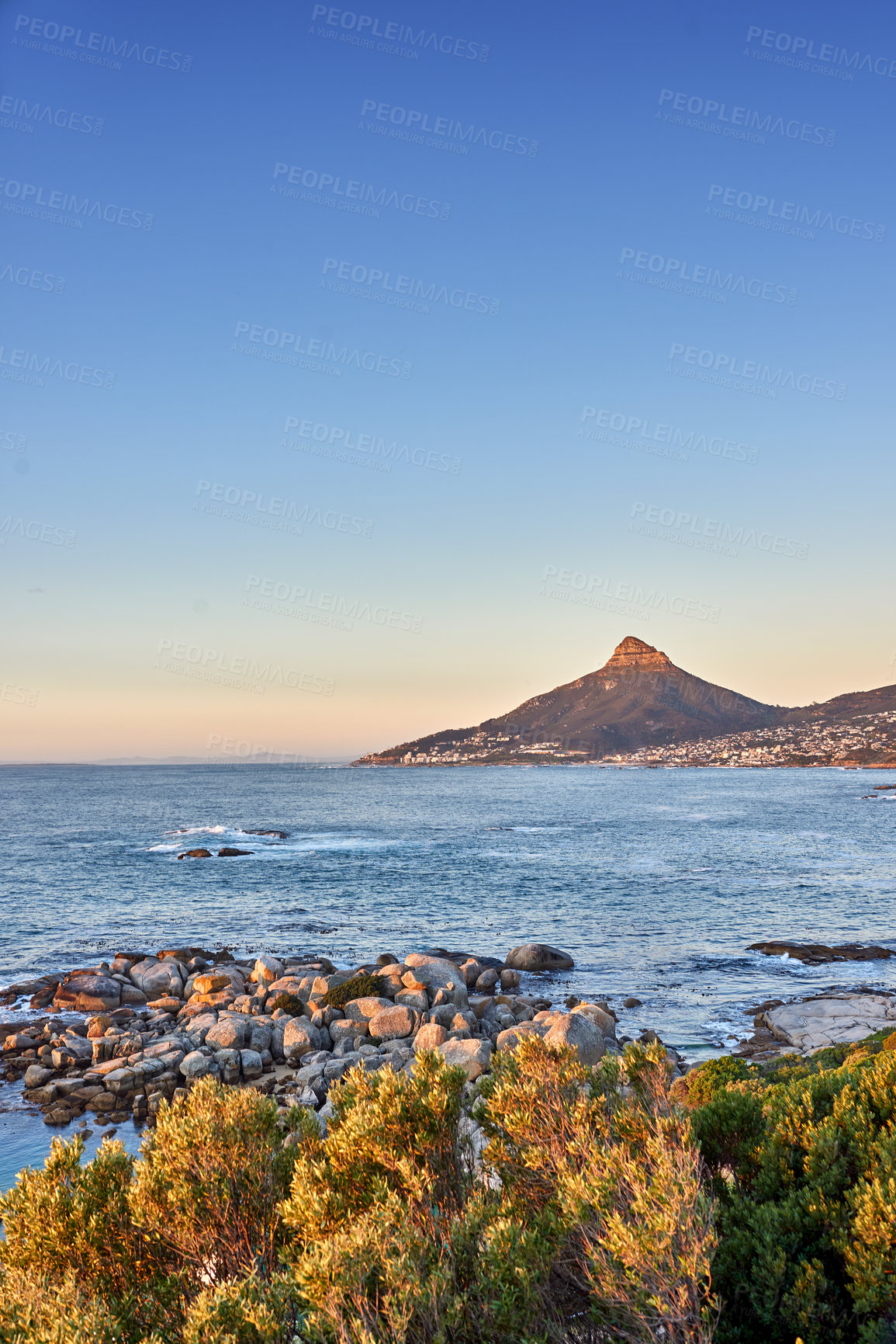 Buy stock photo Seascape view of the majestic ocean with Lions Head mountain in the background. Beautiful calm sea and mountains with a blue sky background and copy space. Stunning nature and wilderness landscape