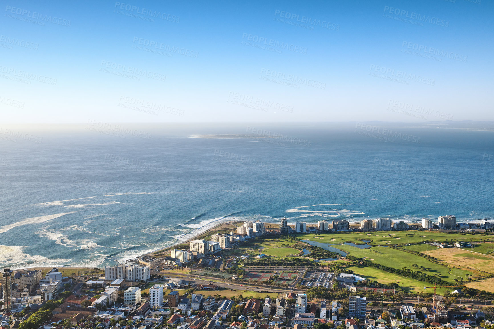 Buy stock photo Landscape view of a beautiful coastal city near the beach on a summer day. Aerial view of a popular tourist urban town with greenery and nature during summer. Top view ocean and residential buildings