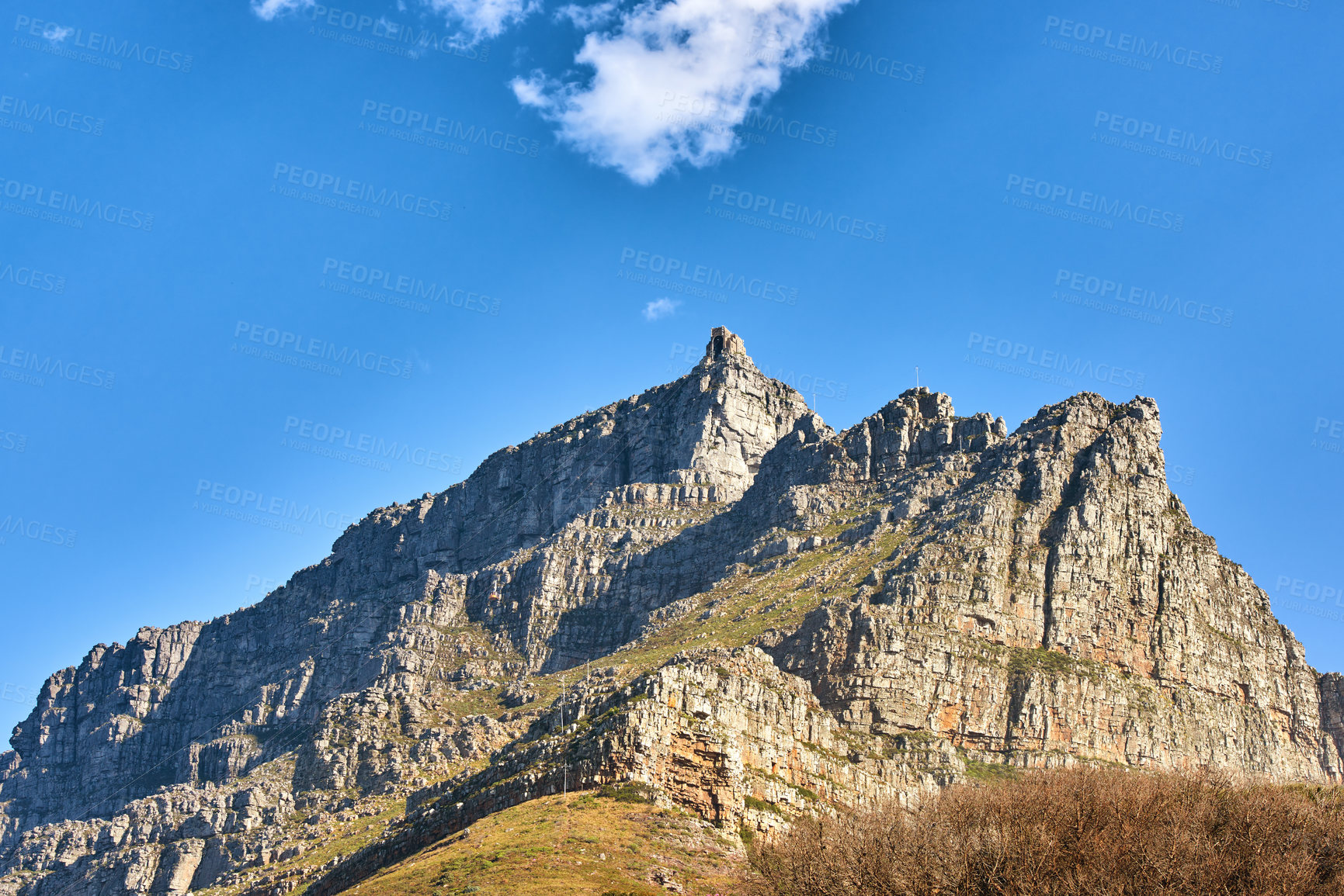 Buy stock photo Beautiful landscape of Table Mountain below with blue sky and copy space. Peaceful and scenic view of a peak with large rocks and grass. A summit in nature ideal for adventure walks and hiking trips