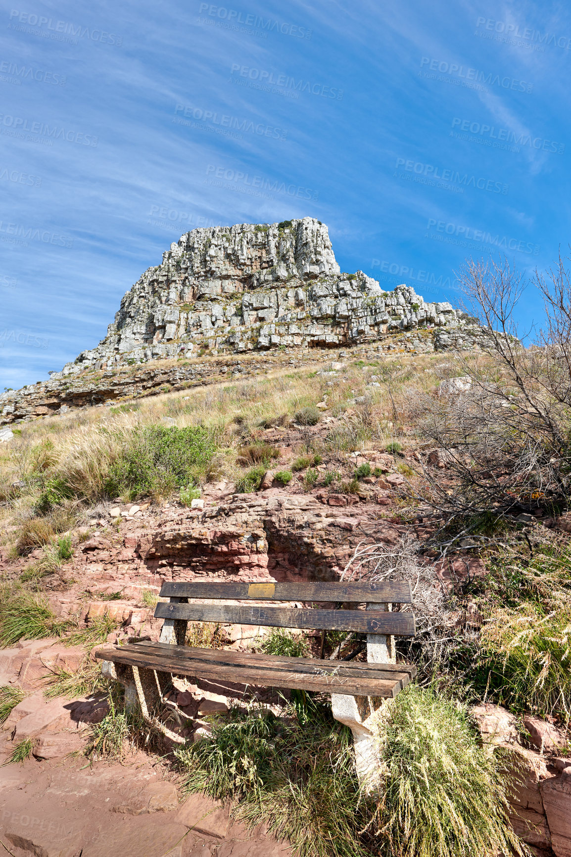 Buy stock photo Bench with a beautiful view of a majestic mountain against a clear blue sky with copy space from below. Relaxing spot for a peaceful break to enjoy the scenic landscape after a hike up a cliff