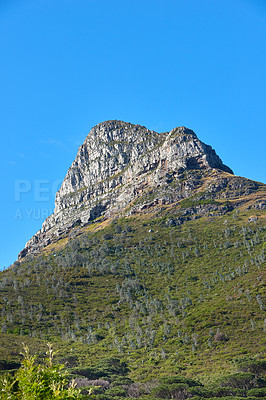 Buy stock photo Copyspace landscape view of the top of a mountain during the day in summer from below. Scenic bottom view of a natural landmark against a clear blue sky. Nature and ecology in the green countryside