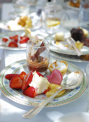 Buy stock photo Closeup of sweet dessert served on porcelain plates and dishes at a high tea event or fine dining restaurant. Texture detail of tasty strawberry fruits, chocolate mousse and italian macarons to eat