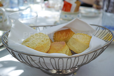 Buy stock photo Fresh baked scones on a kitchen table at a party or event. A serving of a fresh homemade sweet snacks ready to be eaten at a family lunch. Prepared cakes for guests at a lunch date or function 