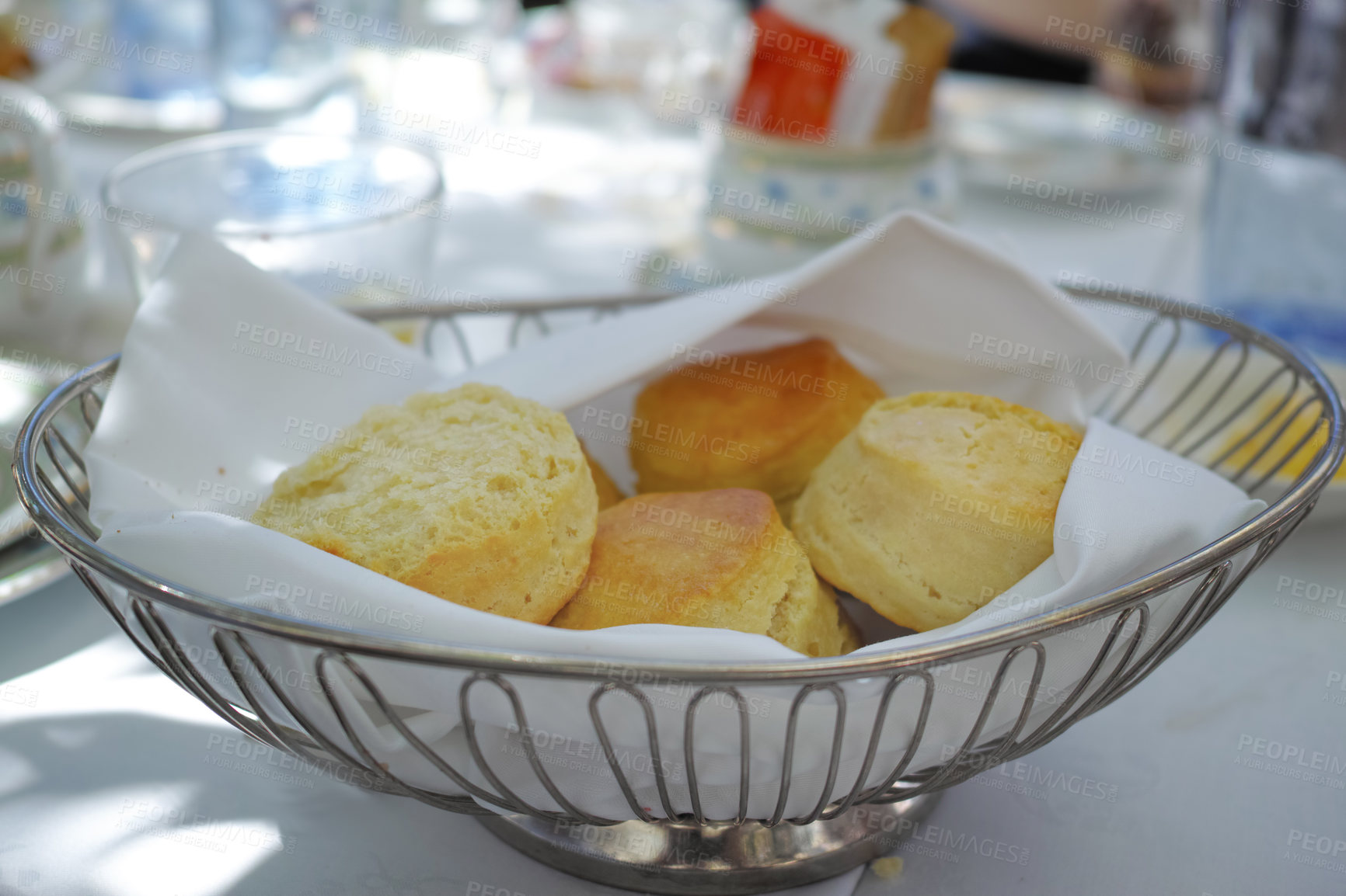 Buy stock photo Fresh baked scones on a kitchen table at a party or event. A serving of a fresh homemade sweet snacks ready to be eaten at a family lunch. Prepared cakes for guests at a lunch date or function 