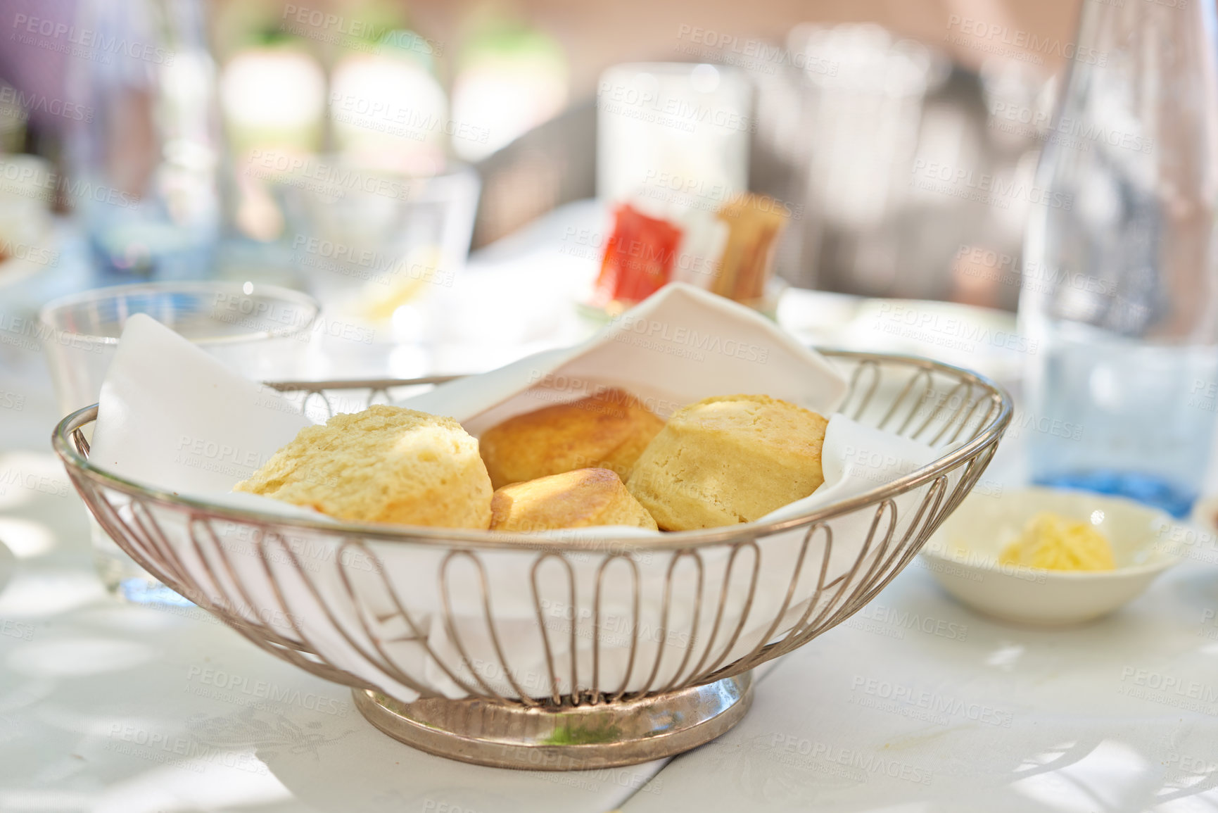 Buy stock photo Fresh baked scones on a kitchen table at a party or event. A serving of a fresh homemade sweet snacks ready to be eaten at a family lunch. Prepared cakes for guests at a lunch date or function