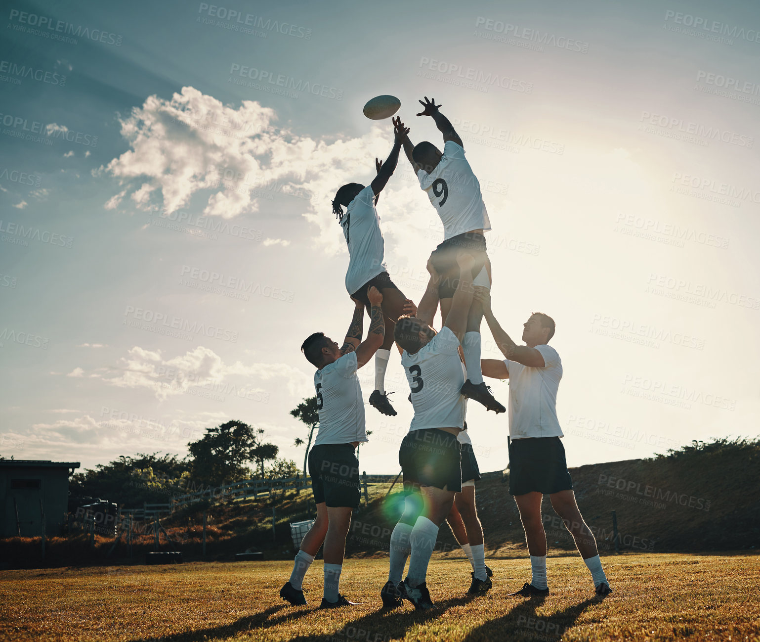 Buy stock photo Full length shot of two handsome young rugby players catching the ball during a lineout on the field