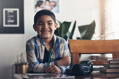 Buy stock photo Shot of an adorable little boy completing a school assignment at home