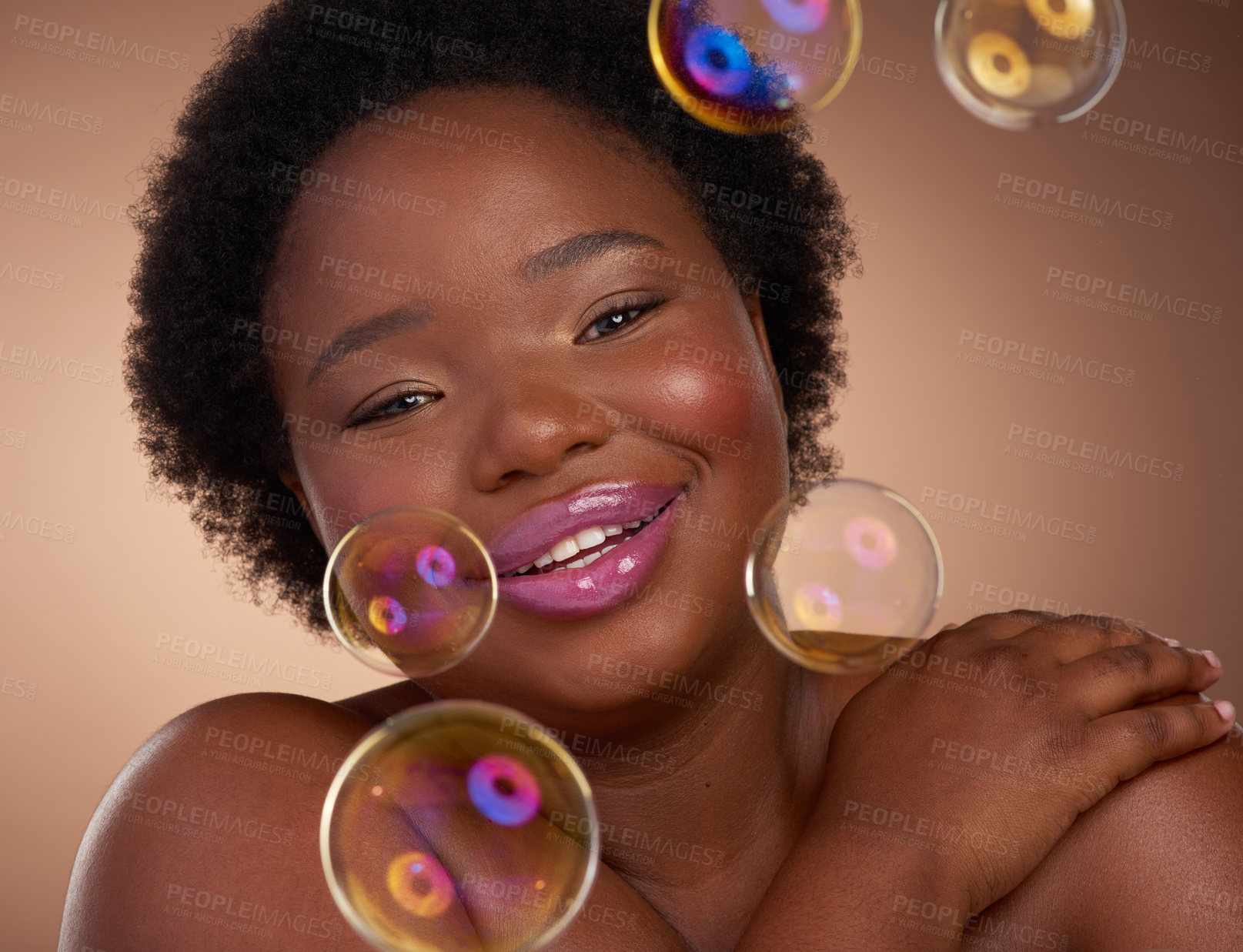 Buy stock photo Happy, black woman and bubbles for beauty, skincare or makeup with shine or glow in portrait. African female model and face with smile, lipstick and cosmetics for self care on beige background