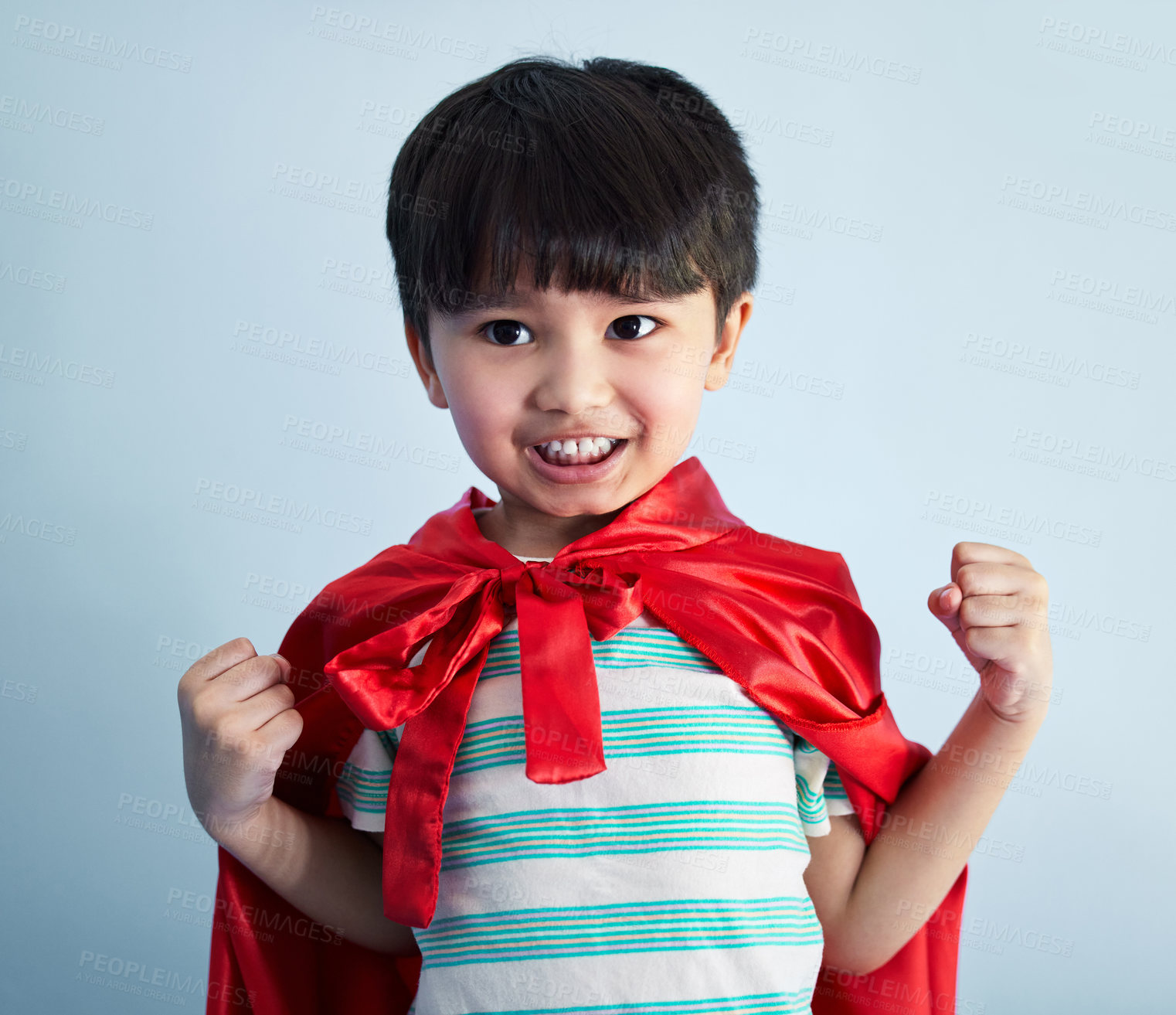 Buy stock photo Shot of an adorable little boy pretending to be a superhero while playing at home