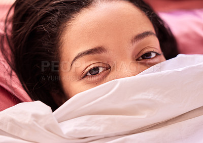 Buy stock photo Portrait of a young woman relaxing under the covers in bed at home