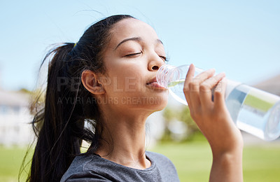 Buy stock photo Shot of a young woman drinking water after her workout at the park