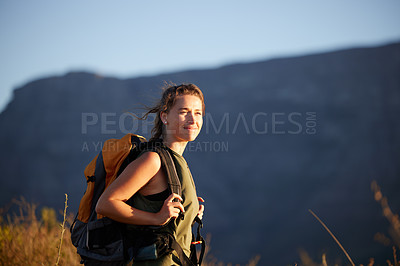 Buy stock photo Shot of a beautiful young woman wearing a backpack while out hiking